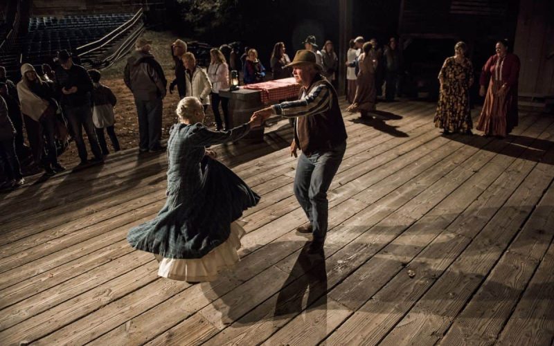 man and woman dancing on rustic wooden barn floor